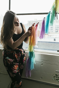 Young woman making multi colored bunting in design studio