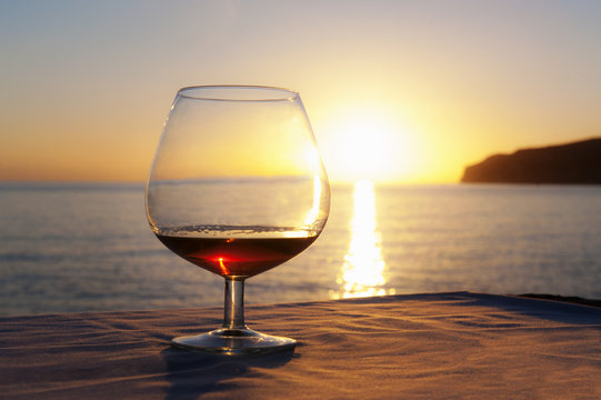 Sunset over sea with brandy glass on table, Mallorca, Spain