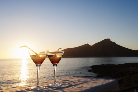 Sunset over sea with two cocktails on table, Mallorca, Spain