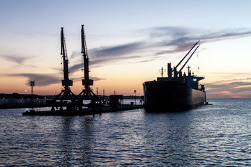 Fototapeta na wymiar Silhouettes of ship and cranes in a port of Santarem city, Brazil