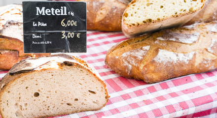 French breads with sign on red checked cloth in Paris market