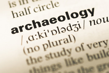 Close up of old English dictionary page with word archaeology