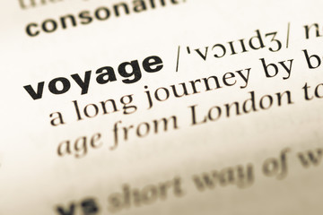 Fototapeta premium Close up of old English dictionary page with word voyage