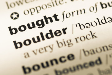 Obraz premium Close up of old English dictionary page with word bought