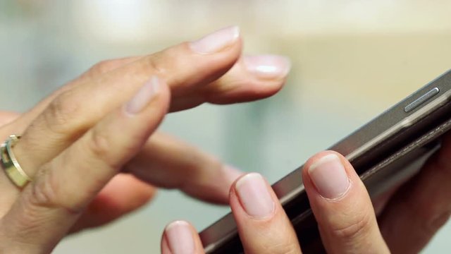 Female hands typing message on smartphone, steadycam shot
