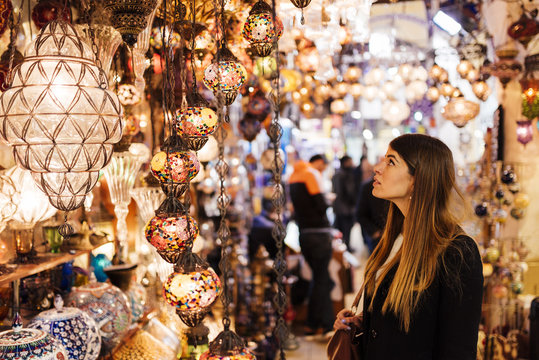 Young woman looking at lights on market stall, Istanbul, Turkey