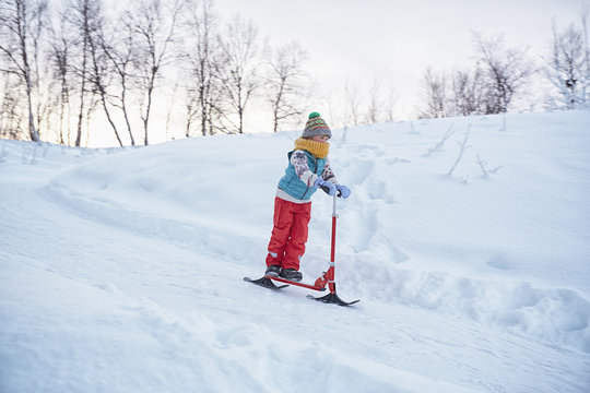 Boy on snow scooter moving down hill, Hemavan,Sweden