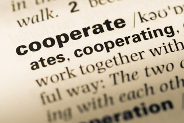 Obraz premium Close up of old English dictionary page with word cooperate