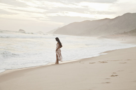 Mid adult woman walking along beach