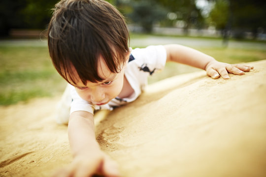 Close up of boy climbing a sand rock