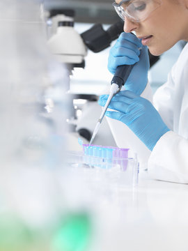 Female scientist pipetting sample into a vial for analytical testing in a laboratory