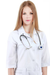 Portrait of young woman doctor with white coat standing in hospi