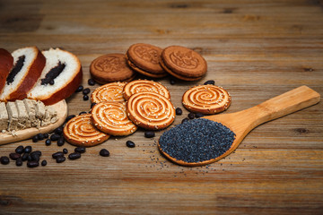 There are Pieces of  Roll with Poppy Seed,Cookies,Halavah,Chocolate Peas,Sweet Food on the Wooden Background