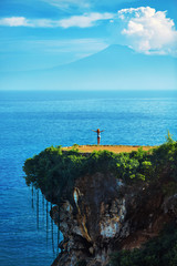 Nature Landscape. Scenic View Of Happy Free Woman With Hands Up On Beautiful Tropical Green Cliff, Sea Rock On Paradise Island. Blue Sky And Ocean On Background. Beauty Scenery. Summer Travel Vacation