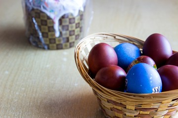 Painted colorful easter eggs in the nest and easter cake. Selective focus