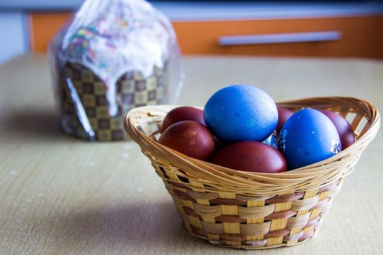 Painted colorful easter eggs in the nest and easter cake. Selective focus