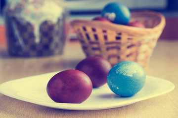 Painted colorful easter eggs and easter cake. Selective focus on eggs. Image with vintage filter