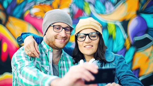 Pair of hipsters doing photo together on smartphone
