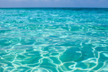 Fototapeta na wymiar Tropical sea water with bright sun light reflections. Sea backgr