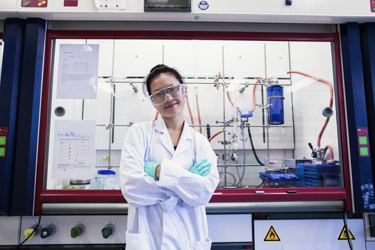 Portrait of young female scientist  in front of fume hood in lab