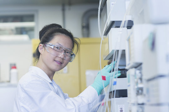 Portrait of young female scientist  using scientific equipment in lab
