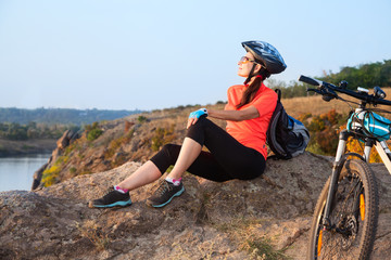 Adult attractive female cyclist is resting.