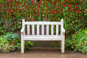 White bench with flower background, selective focus