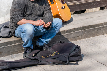 Obraz premium Strassenmusiker zählt seine Einnahmen