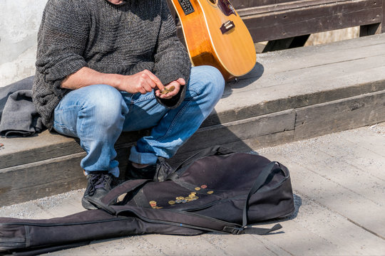 Strassenmusiker z&auml;hlt seine Einnahmen