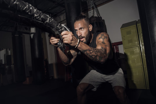 Male boxer pulling battle rope in gym