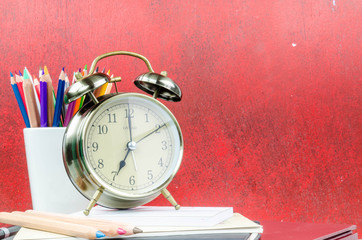Vintage books and clock on wooden table with copy space