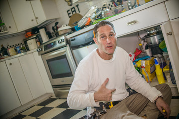 Handyman fixing kitchen sink pipe