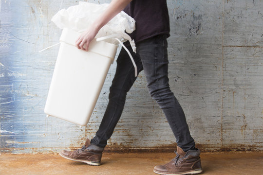 Teenage boy carrying bin with recyclable paper waste