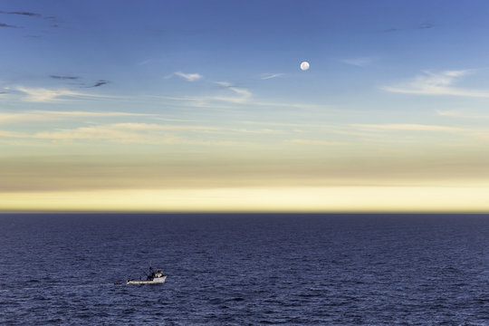 Fishing boat and full moon at dusk, Ponta do Criminoso, Buzios, Rio de Janeiro, Brazil