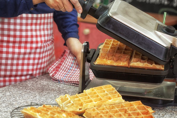 Woman preparing fresh Waffle for dessert