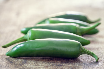 Mexican hot chili Jalapeno peppers on wooden background