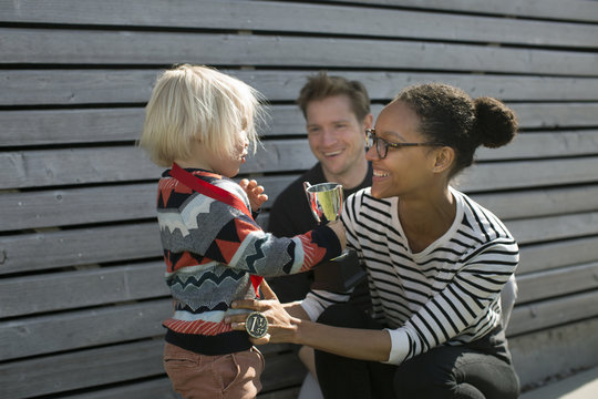 Parents and their son with a trophy