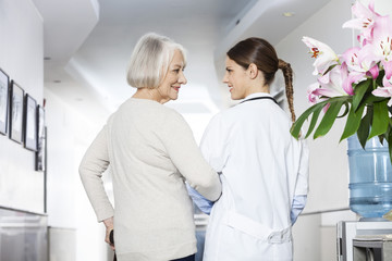 Fototapeta premium Disabled Senior Patient Standing With Doctor At Rehab Center