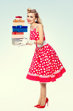 Full body of woman in pin-up style red dress with gift boxes