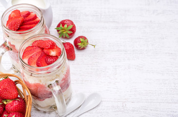 Layered dessert with strawberry and cream cheese in glass jar. Cheesecake.
