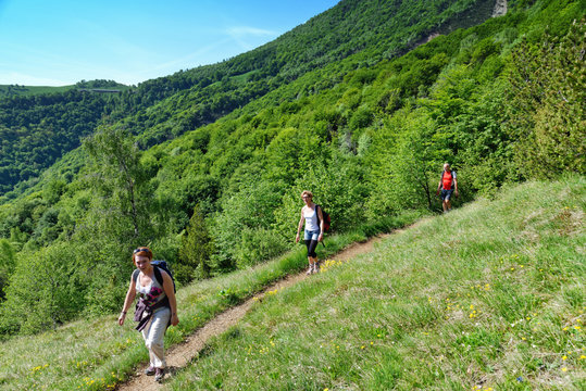 Three mature hikers hiking along hillside path, Grigna, Lecco, Lombardy, Italy