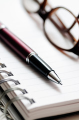 Pen, Glasses, and Spiral Notebook Paper