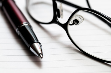 Pen, Eyeglasses, and Notebook Paper Close-Up