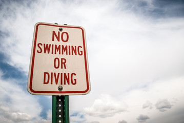 No Swimming or Diving Sign with Cloudy Sky Copy Space