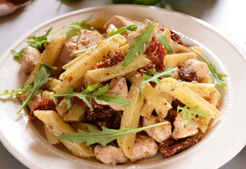Penne pasta with chicken, dried tomatoes and ruckola