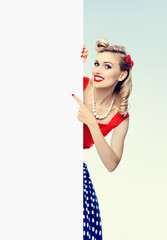 woman in pin-up style dress, showing blank signboard