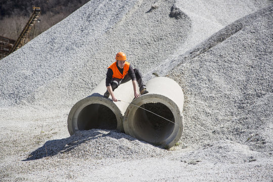 Quarry worker measuring industrial pipes at quarry