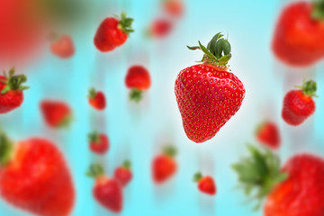 Flying strawberries on blue background