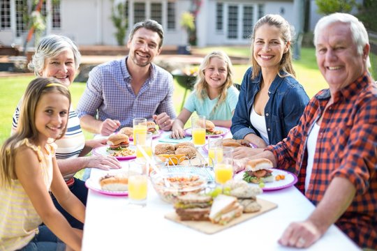 Portrait of cheerful family sitting at table