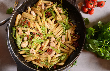 Penne pasta with chicken, dried tomatoes and ruckola